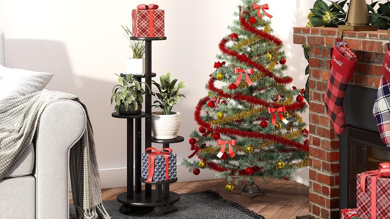 Black five-tiered kiplant stand with wheels next to Christmas tree