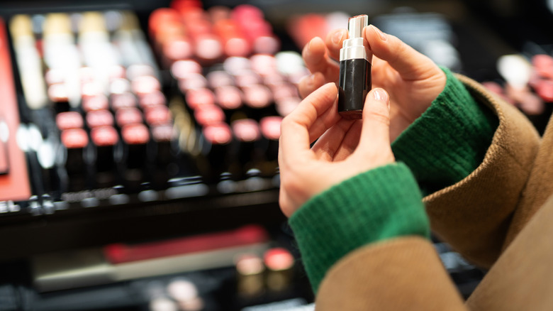 Person holding a tube of lipstick