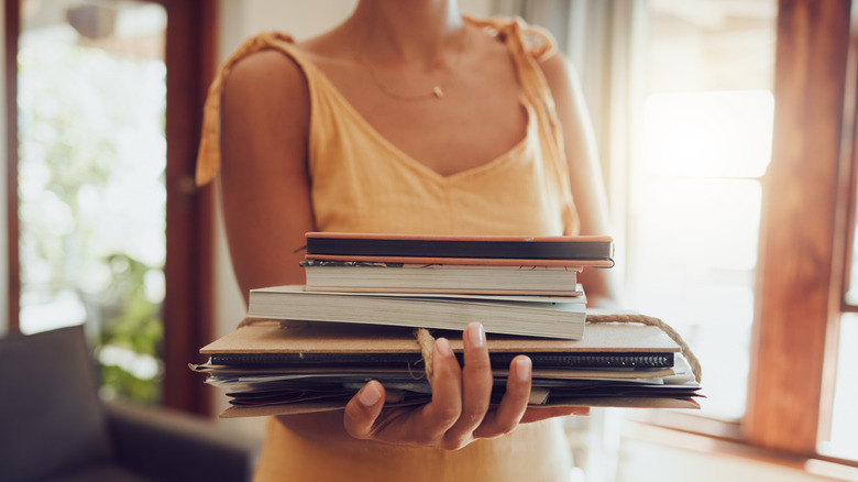 Woman carrying a stack of books