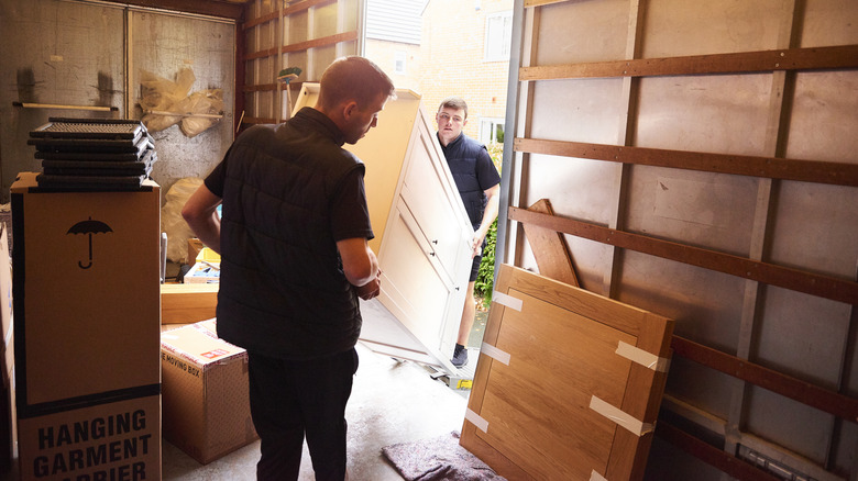 Two men loading furniture into a truck