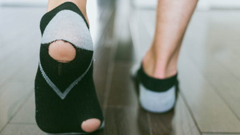 Person wearing socks with holes