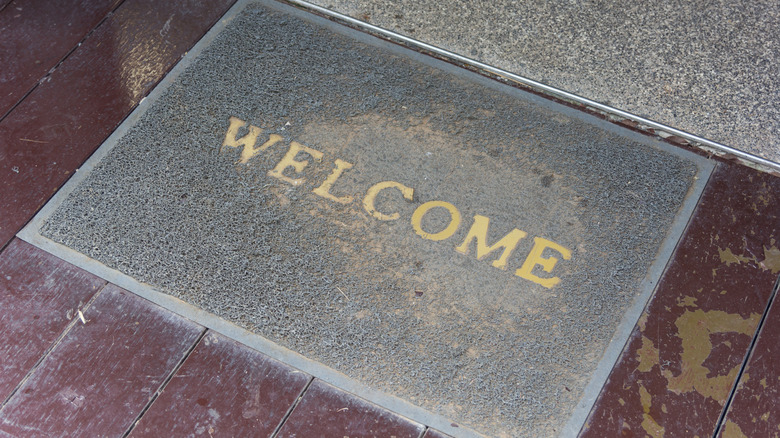 Old gray doormat with gold WELCOME letters