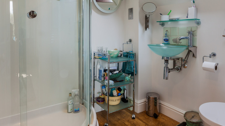 Cluttered bathroom with open storage on rolling cart