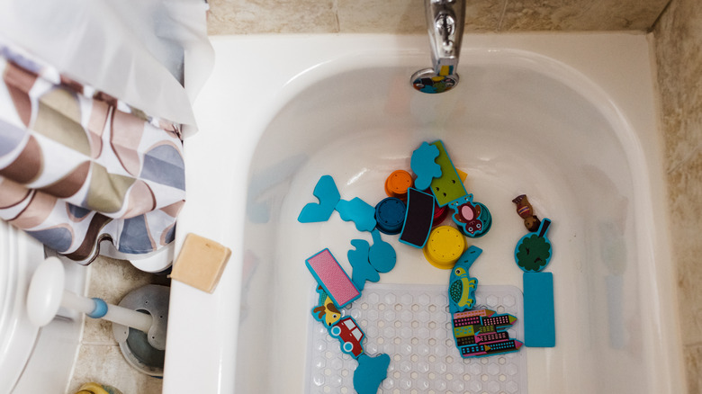 Bath toys left at the bottom of a bathroom tub