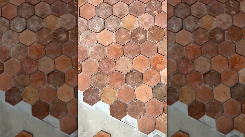 Reclaimed terracotta floor tiles being installed