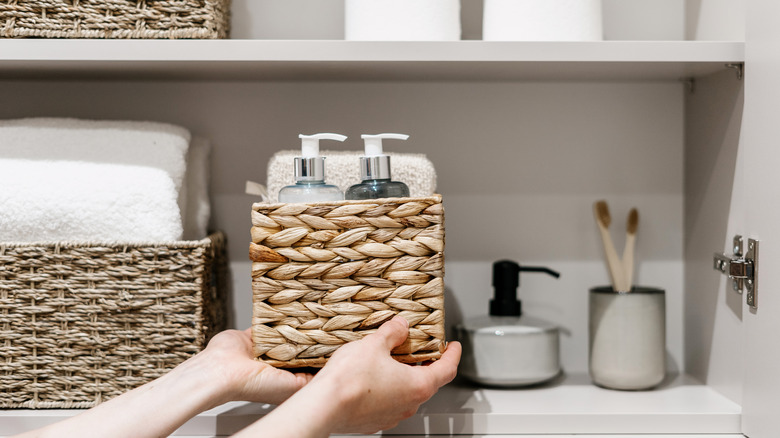 person placing basket on shelf