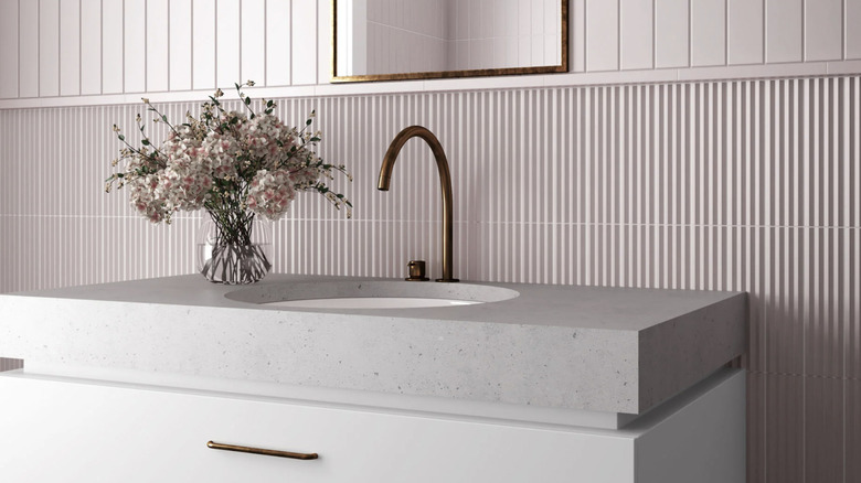 Fluted tile sink backsplash with wider tile above.