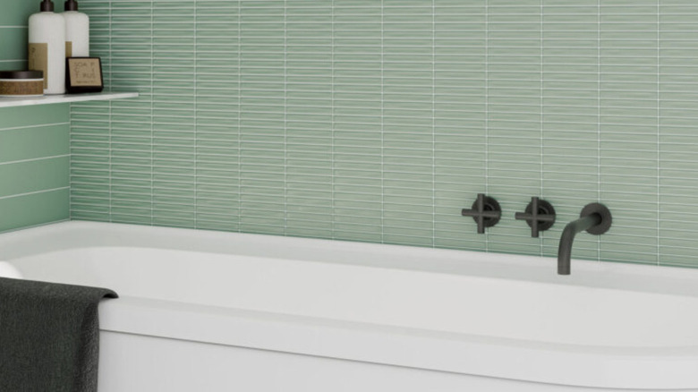 Bathtub with fluted accent wall behind it.