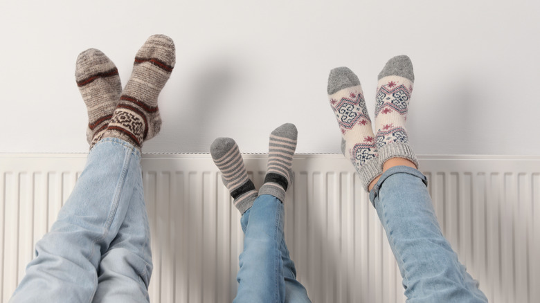 socked feet up on a heater