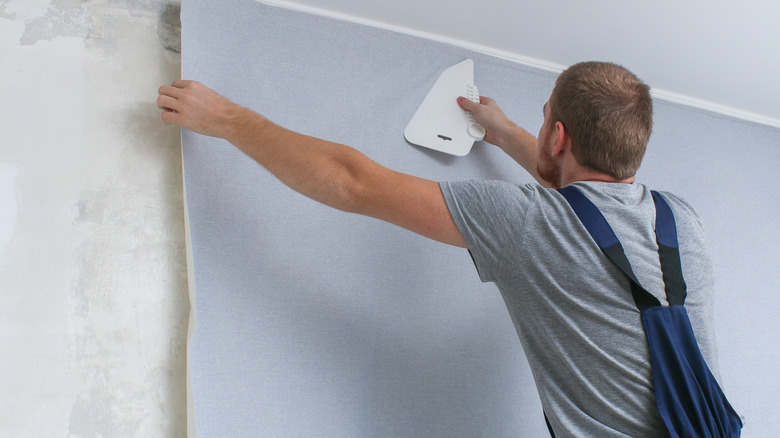 man installing wallpaper