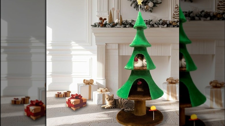 White and brown cat sits curled up inside a Christmas-tree shaped cat tree