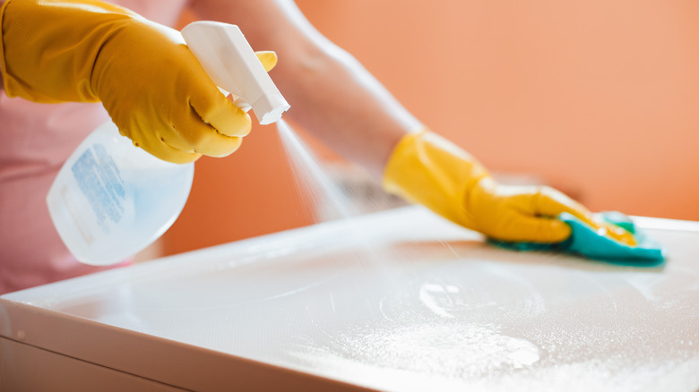 person spraying liquid onto sink