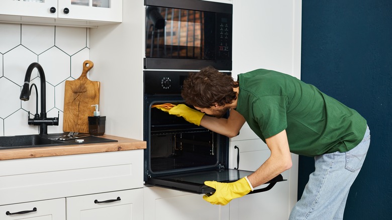 person cleaning the oven