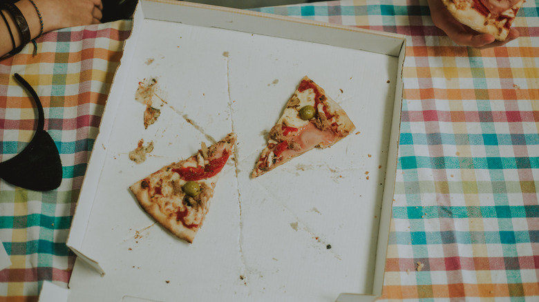 Almost empty pizza box with two slices in it