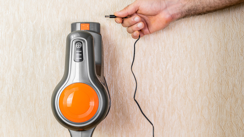 man holding vacuum charging cord