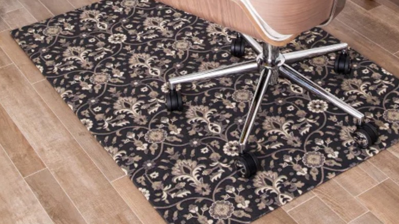 A decorative chair mat sits under a white office chair