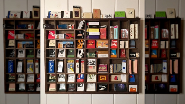 Brown wooden printers tray filled with an assortment of matchbooks from around the world