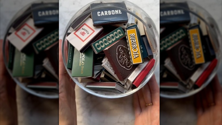 Hands around a bowl filled with matchbooks