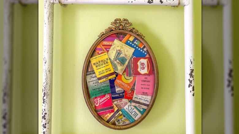 Distressed yellow background with an ornate gold color picture frame and matchbooks framed inside