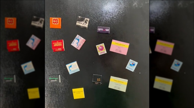 Black fridge with magnets made of matchbooks and matchboxes