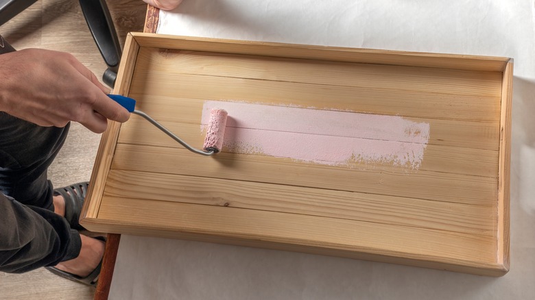 person painting diy wooden tray