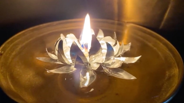 Upcycled tea light holder into water lily floating candle in a brown decorative bowl