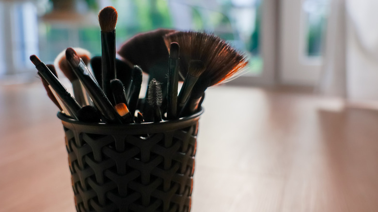 makeup brushes in a textured storage cup