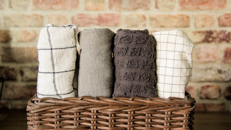 Rolled kitchen towels in a basket on the counter