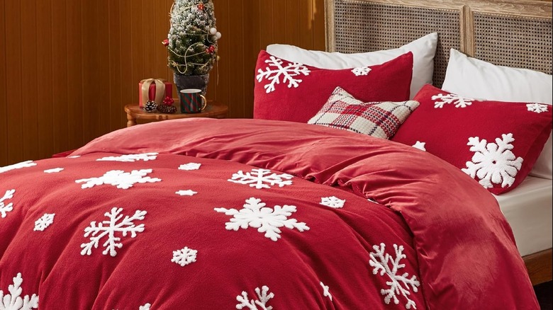 A red duvet cover with snowflakes on a bed