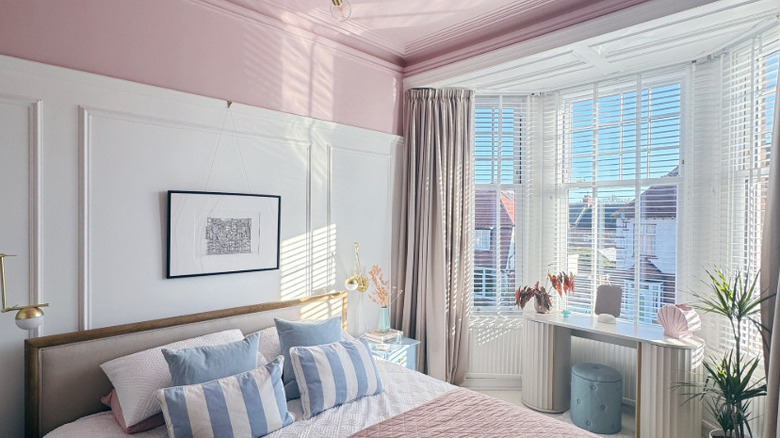 A bright bedroom with pink wall trim and ceiling.