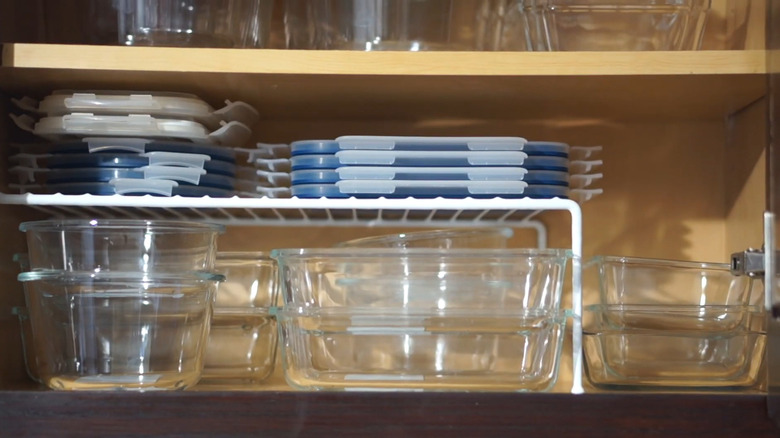 White wire shelf riser with Tupperware lids on top and containers on the bottom