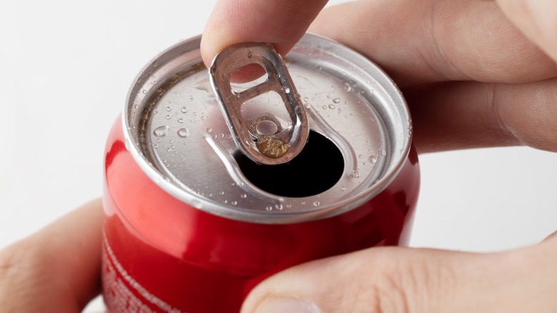 Person opening a can of soda