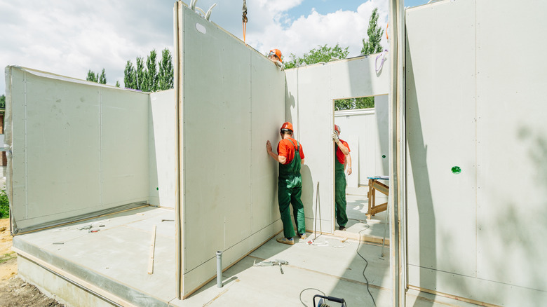 Men building with prefab walls