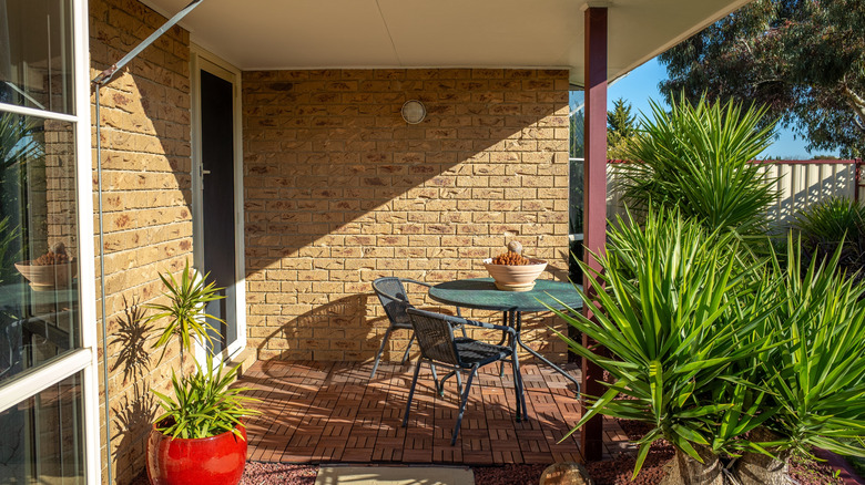 A small dining area on the back porch of a brick house