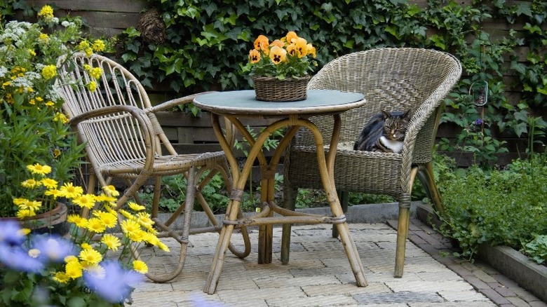 A simple wicker chair and table in a small patio spot.