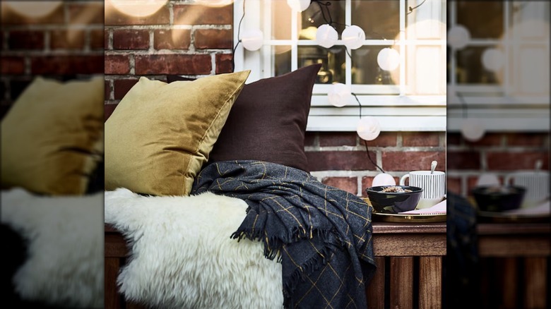 A sheepskin throw is draped on a patio bench