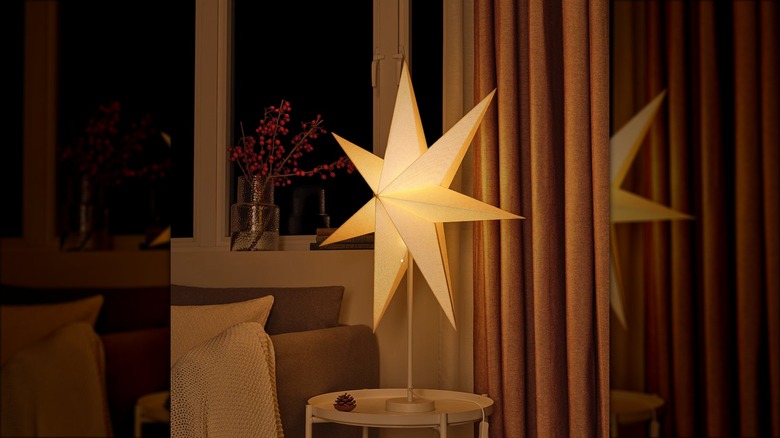 A star shaped paper lamp sits on a side table