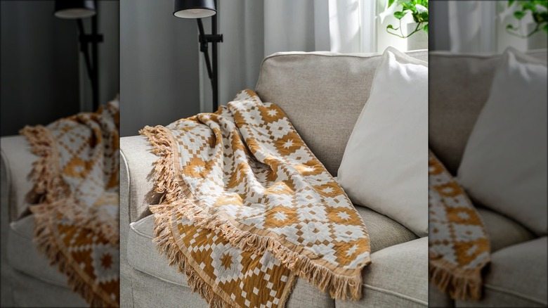 A throw blanket is draped on a couch