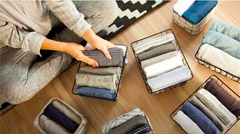 Woman folding clothes in baskets