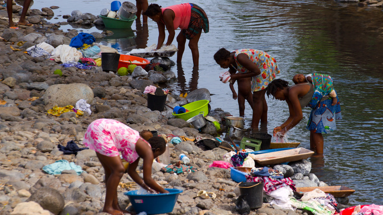 African people washing dirty clothes on the banks of a river