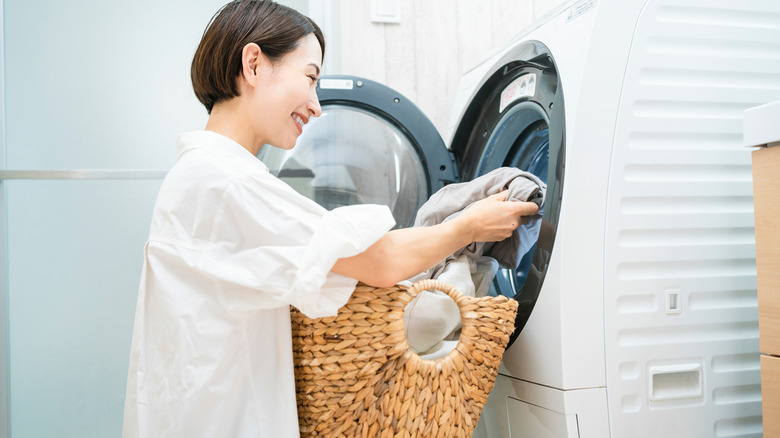 Woman putting clothes in washer