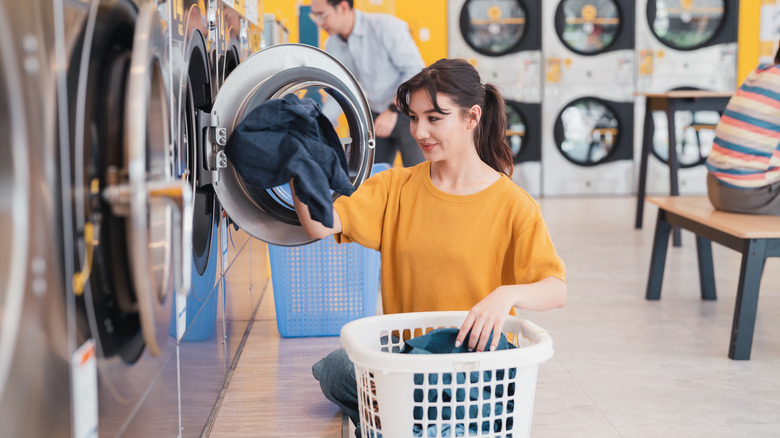 People washing clothes at a laundromat