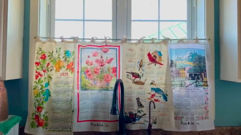 A window curtain made of dish towels stitched together