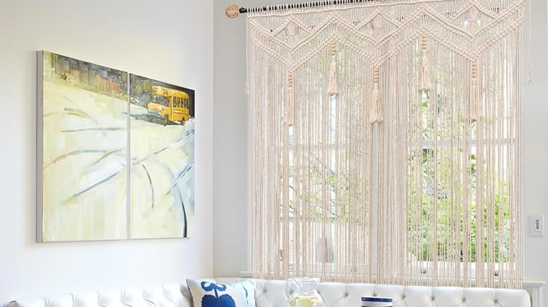 light beaded macrame curtain hanging over white seating