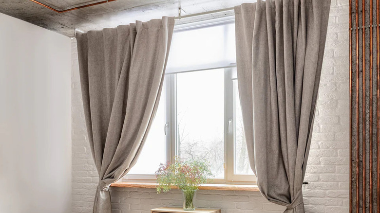 oatmeal-colored flax linen curtains over window and white brick-style wall