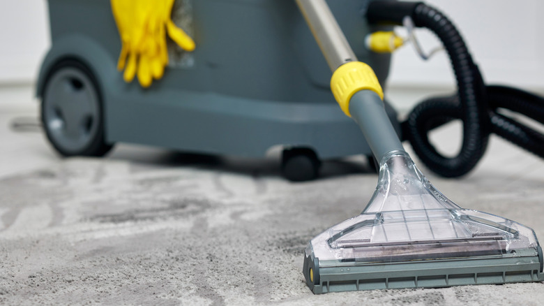 A wet/dry shop vacuum on grey carpet