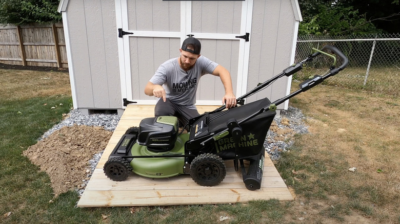 bearded man pointing at green push mower