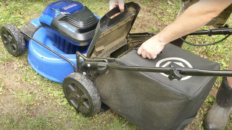 man starting blue electric mower