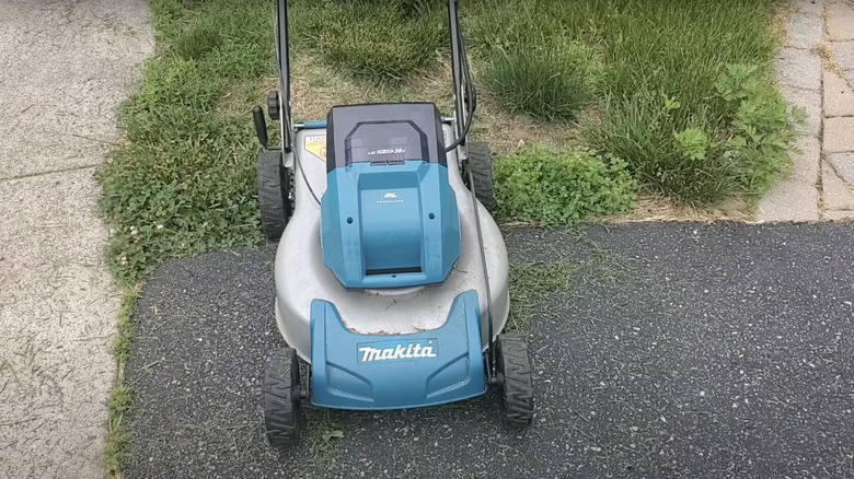 battery-powered lawn mower on asphalt driveway