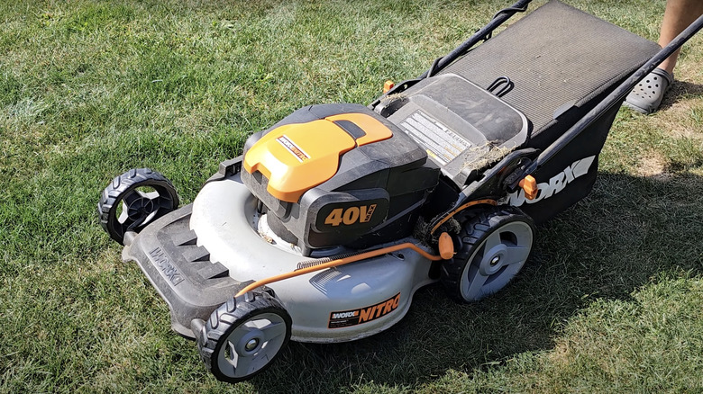 man pushing cordless lawn mower